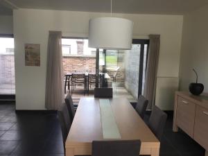 comedor con mesa de madera y sillas en Maaszicht, en Maasmechelen