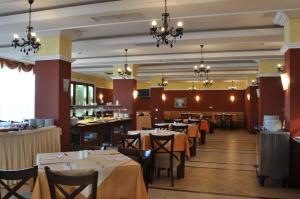 a dining room with tables and chairs and chandeliers at Private Studio 1st line in Pomorie