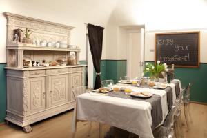 a dining room with a table with food on it at Virgula B&B in Cuneo