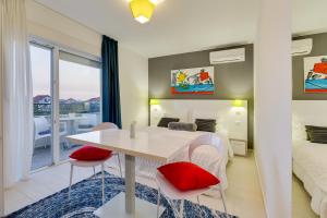 Schlafzimmer mit einem Bett und einem Tisch mit roten Kissen in der Unterkunft Villa Liburnum in Zadar