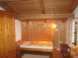 a bedroom with a bed in a wooden wall at Ferienhaus Zopfhäusl in Böbrach