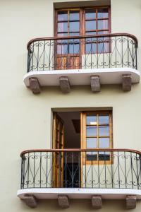 a building with two balconies and a window at Hotel Casa Ecuatreasures Centro Historico in Quito