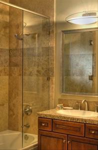 a bathroom with a shower and a sink and a mirror at Casitas at Sabino Springs in Tucson