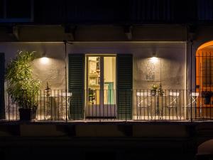 a building with a balcony with chairs and a door at Virgula B&B in Cuneo