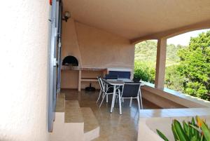 a patio with a table and chairs on a balcony at Residence "U LATONU" in Porto-Vecchio