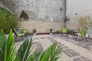 eine Terrasse mit Stühlen, Tischen und Ziegelwand in der Unterkunft The Well Luxury Rooms in Zadar