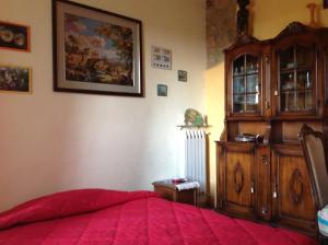 a bedroom with a red bed and a wooden cabinet at La Vecchia Quercia in Pergine Valdarno +75 photos