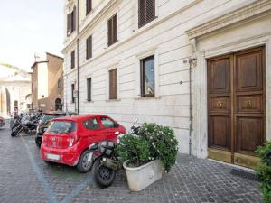 czerwony samochód stoi obok budynku w obiekcie Al Portico 39 Apartment w Rzymie +4 zdjęcia