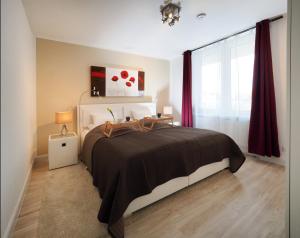Hohen WieschendorfにあるWhite Breeze 201のベッドルーム1室(赤いカーテン付きの大型ベッド1台付)