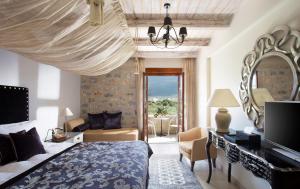 een slaapkamer met een kingsize bed en een spiegel bij Porto Vitilo Boutique Hotel in Karavostasion