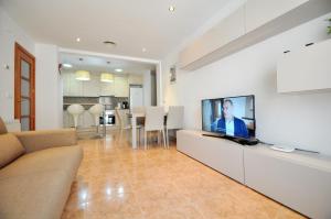 sala de estar con TV de pantalla plana en la barra en Apartament Duplex Llaverias, en Lloret de Mar