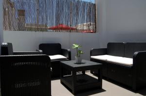 マラガにあるアパルトメントス サン パブロの椅子2脚とテーブル付きの待合室
