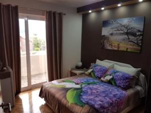 1 dormitorio con 1 cama con una pintura en la pared en Apartments Vila Galileo, en Budva