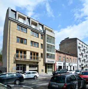 een groot gebouw met auto's geparkeerd op een parkeerplaats bij Vinyl Apartment Old Town in Krakau