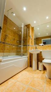 a bathroom with a toilet, tub, sink and shower at Drury Court Hotel in Dublin