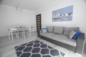a living room with a couch and a table with sailboats at Mazuria Apartamenty in Mikołajki