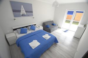 a bedroom with a blue bed and a sailboat on the wall at Mazuria Apartamenty in Mikołajki