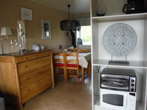 a kitchen and dining room with a table and a microwave at Maison Joseph in Hotton