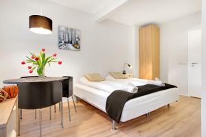Un dormitorio con una cama y una mesa con un jarrón de flores en Alfred's Studios, en Reikiavik