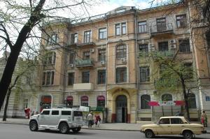 un coche viejo estacionado frente a un edificio en Malon Apartments, en Járkov