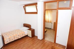 um pequeno quarto com uma cama e um espelho em Apartmani Apollo em Split