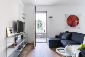 ミラノにあるStylish 1-bedroom flatのリビングルーム(青いソファ、テレビ付)