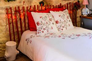 um quarto com uma cama com almofadas vermelhas e brancas em Le Duplex de Lapparan em Saint-Drézéry