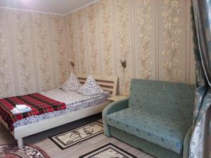 a small bedroom with a bed and a chair at Apartments on Shashkevycha, 16 in Truskavets