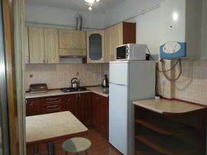 a small kitchen with a white refrigerator and a table at Apartments on Shashkevycha, 16 in Truskavets