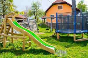 um parque infantil com um escorrega na relva em Guest house Domačija Krnc em Hrib pri Hinjah