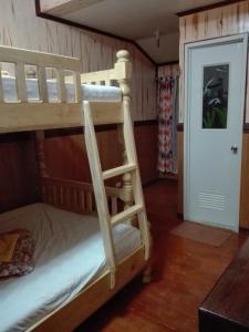 a bunk bed room with two bunk beds and a door at Koreen Guest House in Banaue