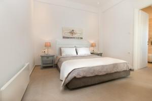 a white bedroom with a bed and two night stands at Villa Maria Naxos -with new hot tub in Naxos Chora +22 photos