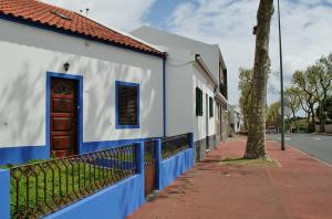 a blue and white building with a door and a sidewalk at Casa Azul Natura in Ponta Delgada