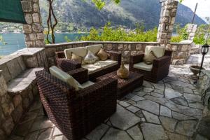 un patio con muebles de mimbre y vistas al agua en Hill Apartments, en Kotor