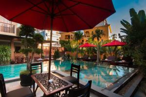 a table with an umbrella next to a swimming pool at BB Angkor Residence in Siem Reap