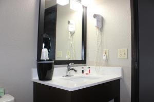 a bathroom with a sink and a mirror and a phone at Super 8 Grand Rapids City Center in Wyoming
