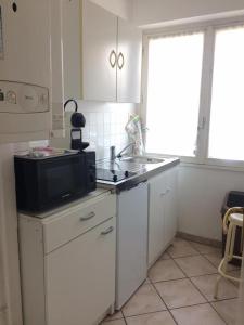 a kitchen with a sink and a microwave at Residence les Goelands in Ouistreham