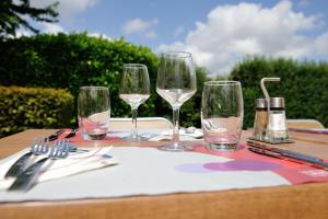 a table with four wine glasses on top of it at Campanile Saint-Avold in Saint-Avold +20 photos