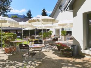 a patio with tables and chairs with umbrellas at Campanile Saint-Avold in Saint-Avold