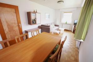 a dining room and living room with a wooden table at Wolfsbau Ferienwohnung in Langelsheim