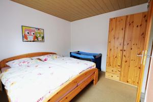 a bedroom with a bed and a wooden door at Wolfsbau Ferienwohnung in Langelsheim