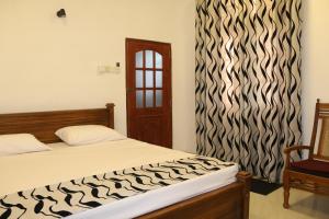 Un dormitorio con una cama y una silla y una ventana. en Villa No1, en Bentota
