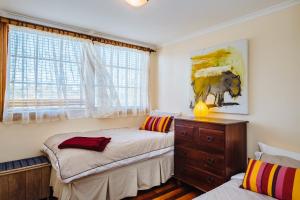 a bedroom with two beds and a painting of a cow at The Blue Beach House in Quinns Rocks