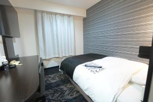 una camera d'albergo con letto e scrivania di APA Hotel Suzuka-Chuou a Suzuka