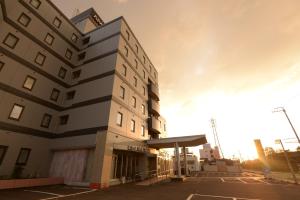 un edificio con una gasolinera delante de él en APA Hotel Suzuka-Chuou, en Suzuka