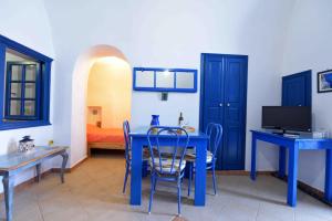 Éxo GoniáにあるKleo's Guesthouseの青いテーブルと椅子、ベッドが備わる客室です。