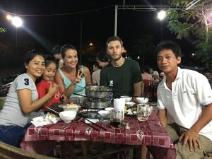 a group of people sitting at a table at night at Blue Beach Homestay in Hoi An