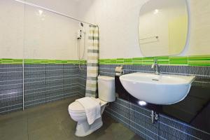 a bathroom with a sink and a toilet and a mirror at Kiss Hometel in Ao Nang Beach