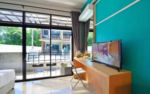 a living room with a tv and a large window at Kiss Hometel in Ao Nang Beach