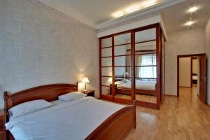 a bedroom with a large bed and a mirror at Oksana's Apartments in Saint Petersburg